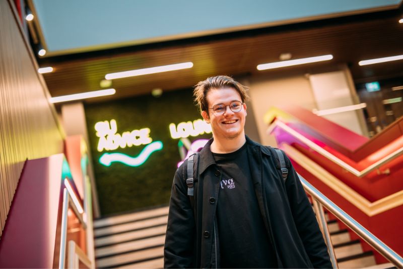 male student walking down the stairs in One Elmwood