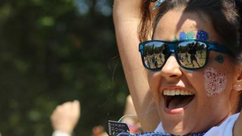 female student wearing sunglasses and smiling in a summer carnival setting