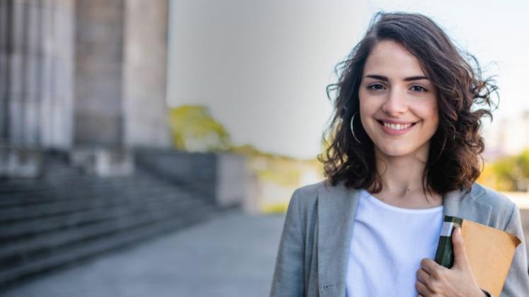 student standing outside a court smiling