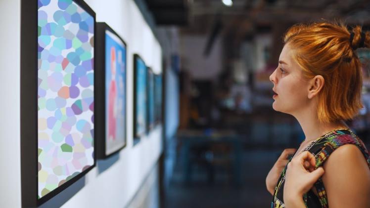 student looking at artwork in a gallery