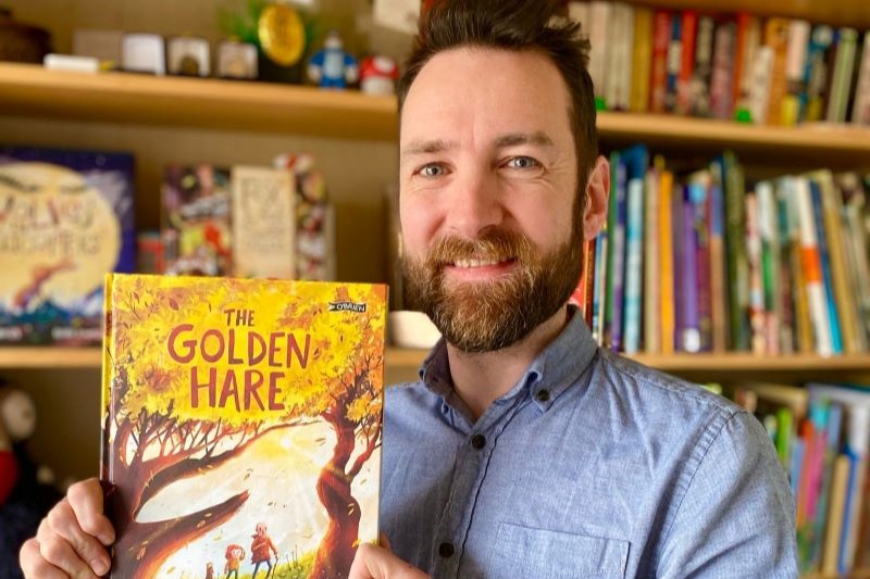 Image of award-winning author & illustrator, Paddy Donnelly with one of his books.