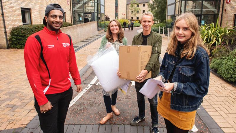 Student standing beside parents and QUB staff member on move in day