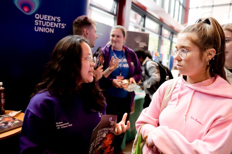 student speaking to another student at an SU information stall