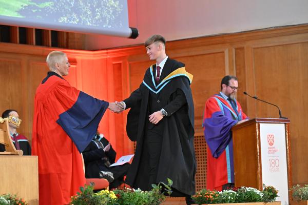 15. Graduate is congratulated on stage.