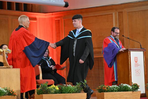 17. Graduate takes to the stage to celebrate their accomplishments.