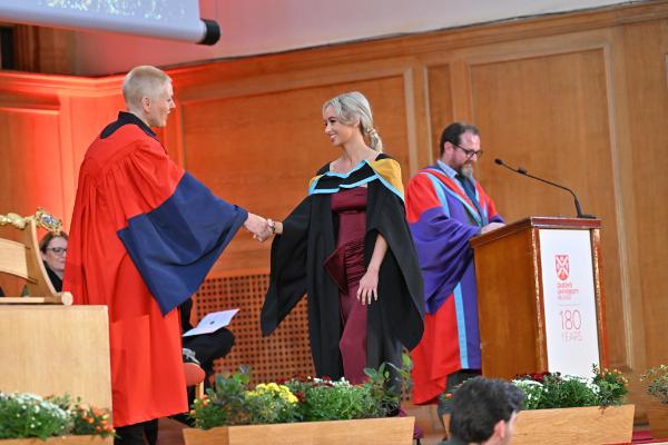 18. A moment of pride as a graduate is congratulated on their commitment and hard work.