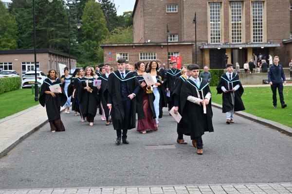 22. R-City graduates make their way through the Queen’s campus, celebrating together after the ceremony.