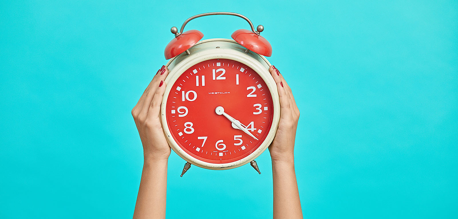 Hands holding a clock