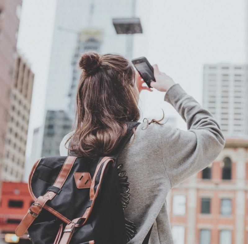 Girl point phone towards sky and taking a pitcure