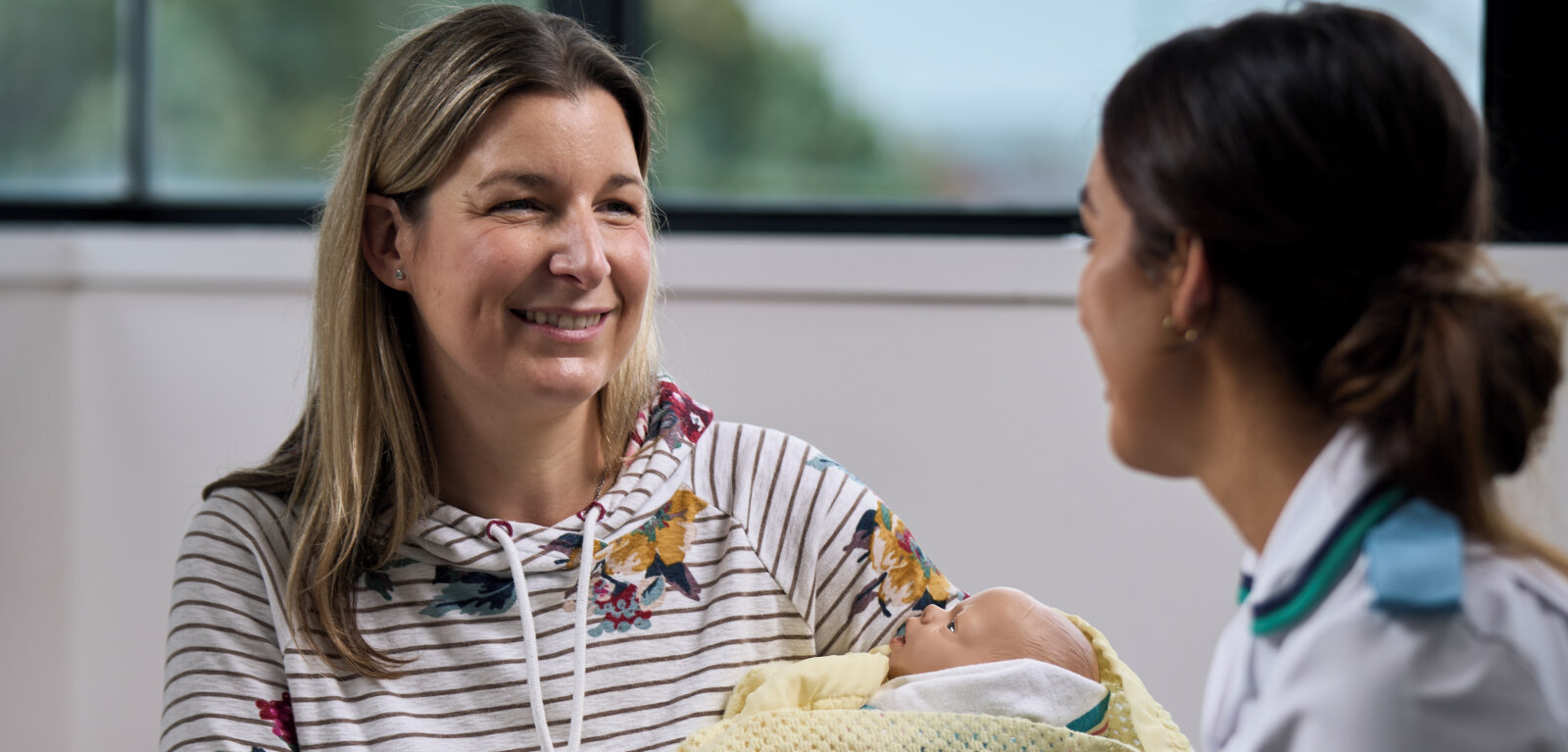 Midwifery students supporting a patient with her baby