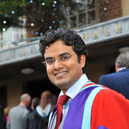 International student outside Whitla hall attending winter graduation