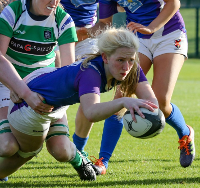 Rugby player storms forward with a rugby ball