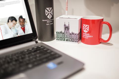 Laptop, mug, post it notes on table