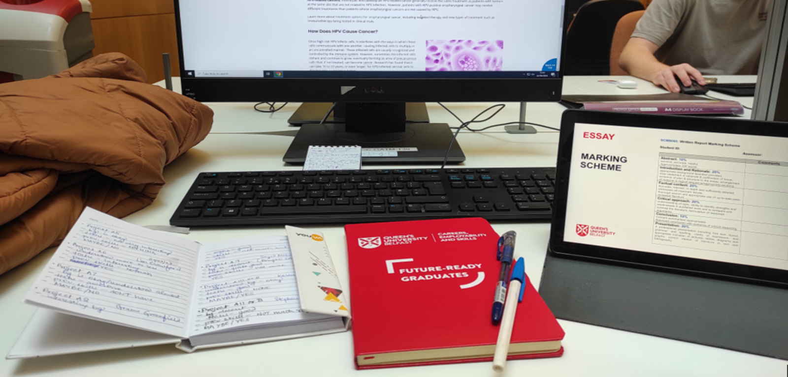 Student Adriparna's desk set up, including a monitor, laptop and notebook