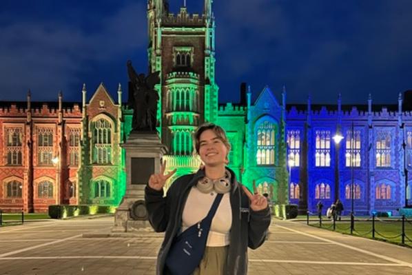 Student Allison stands in front of lit up Lanyon building