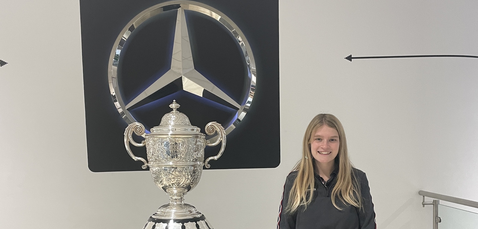 Charlotte Jennings next to F1 trophy