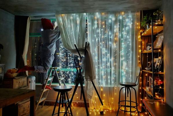 Person decorating room with fairy lights