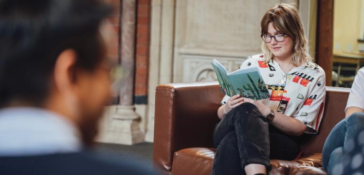 Female QUB student reads book in the Graduate School