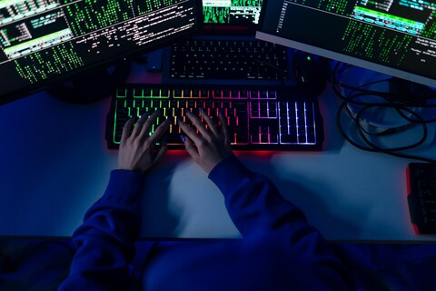 Person with hands resting on a lit up keyboard