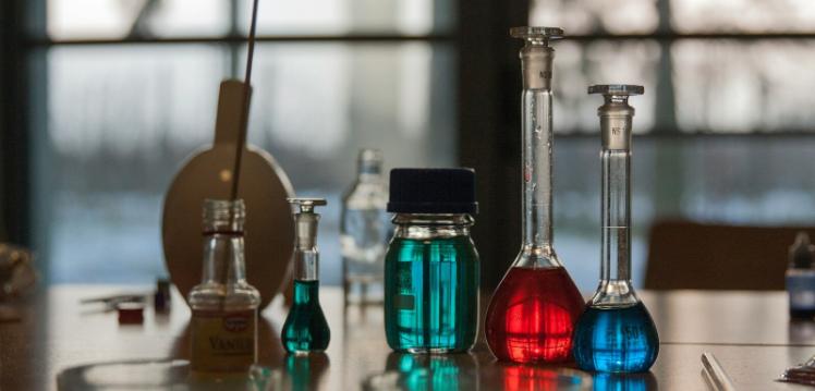 Glass test tubes and vials filled with coloured liquid
