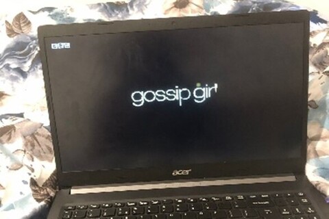 Laptop showing Gossip Girl title card on screen