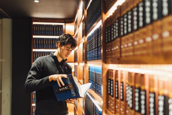 Student Lucas looks through book in the McClay Library