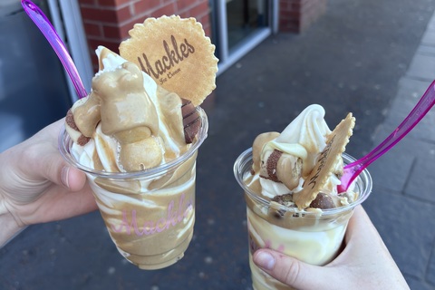 Two students holding tubs of Mackles ice cream from Belfast