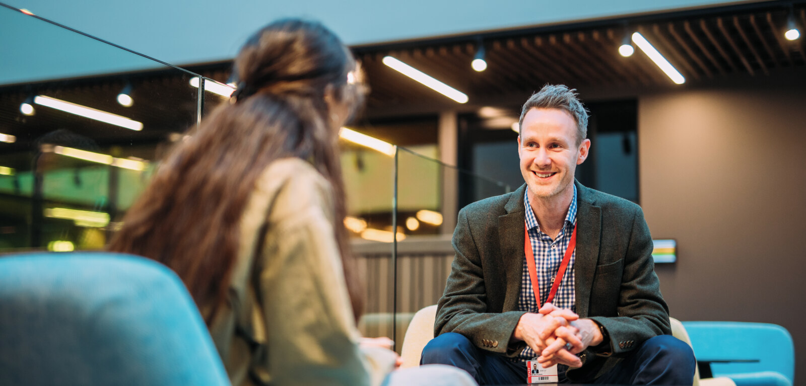 Male QUB staff member talking to female student inside the One Elmwood Student Centre