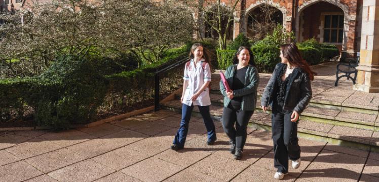 Three mature students walk through the Quad