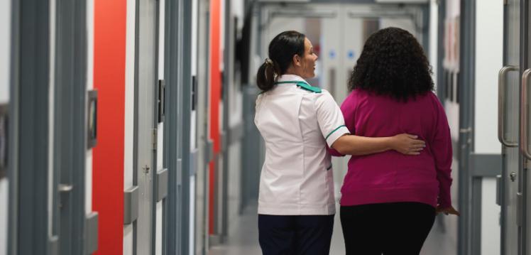 Midwifery student walking with female patient