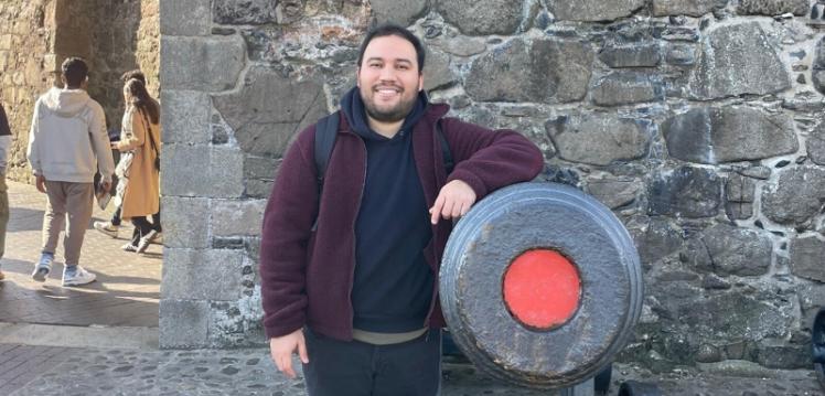 Student Miguel stands beside cannon at Carrickfergus Castle