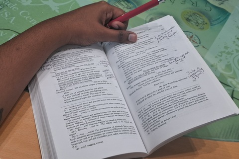 Student Natasha making notes in the margins of a book