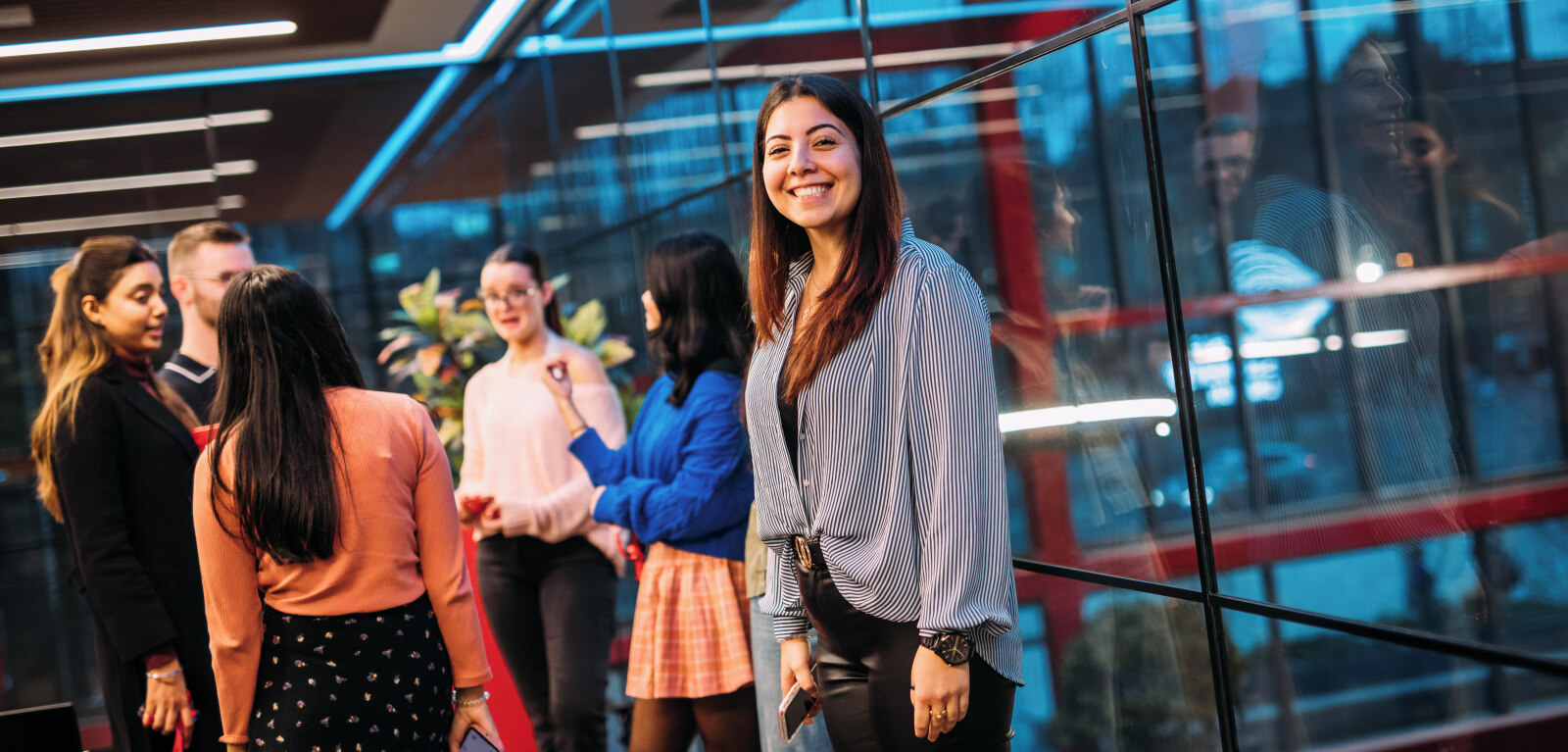 Student smiling at camera beside a group of other students