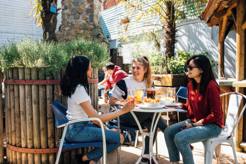 Three students having lunch in the Parlour bar's backyard