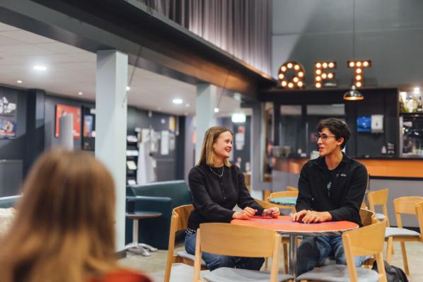 Two students sitting in the QFT foyer