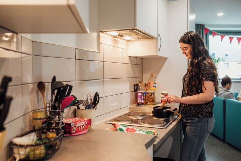 Student cooking in Queen's accommodation