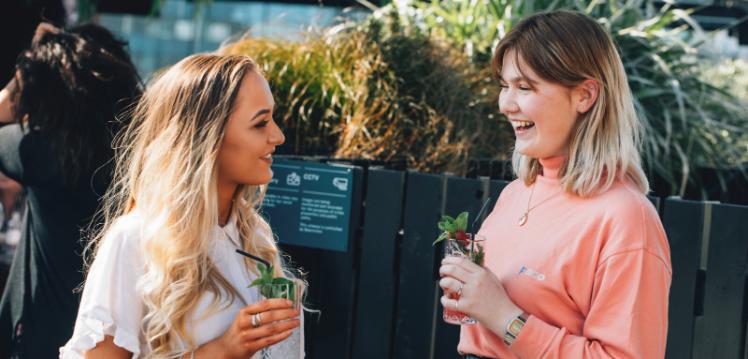 Two female students having a drink outside in Belfast