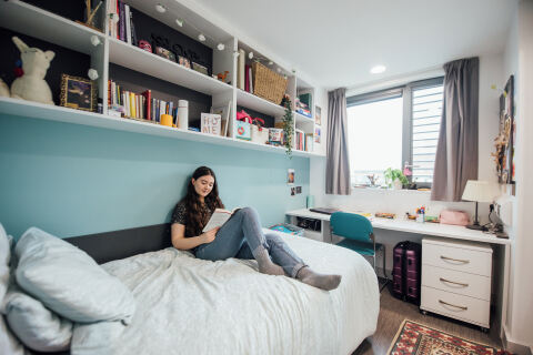 Student reading on bed in accommodation