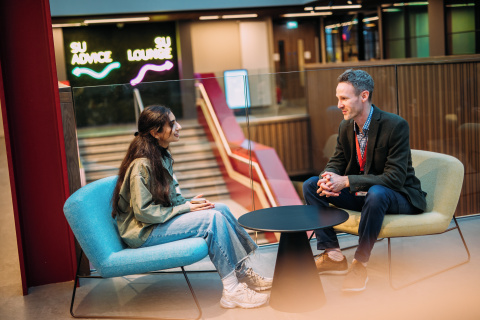 Student receiving advice from staff member inside students' union