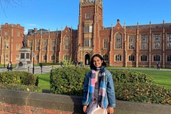 Medicine student Radhika sitting on wall outside Lanyon building