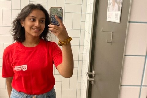 Student ambassador wearing red Queens t-shirt