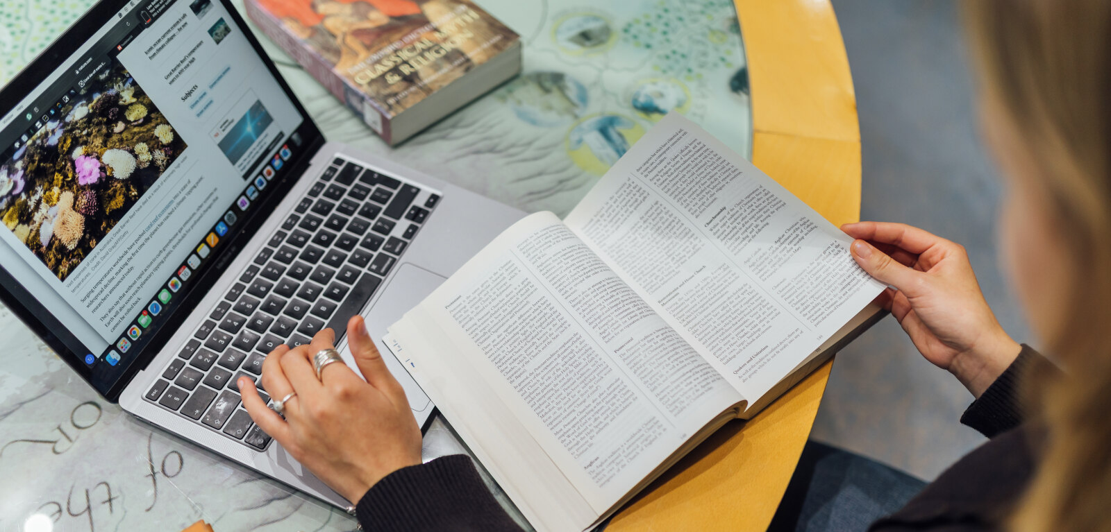 Student studying with laptop and books in CS Lewis Reading room