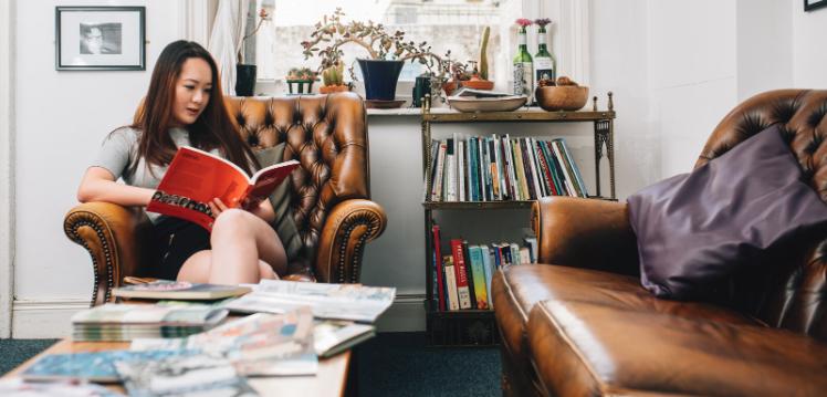 Student reading book in Queen's School of English