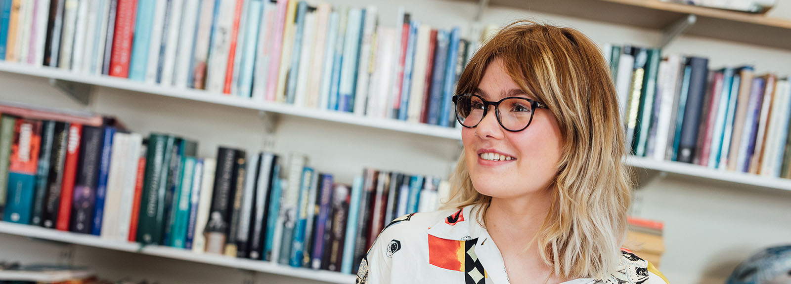 Student in front of bookshelves