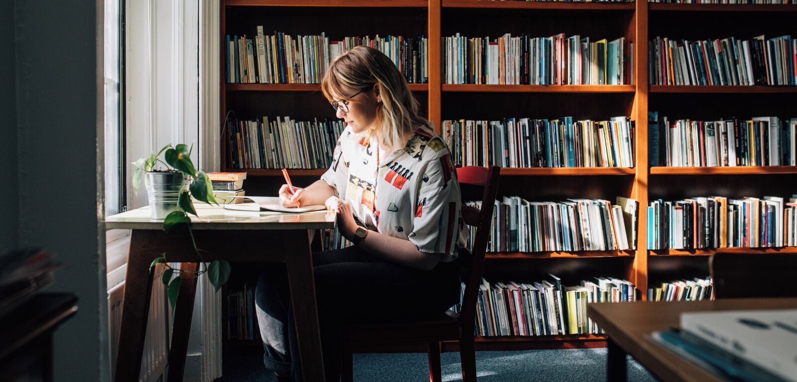 Student writing at desk