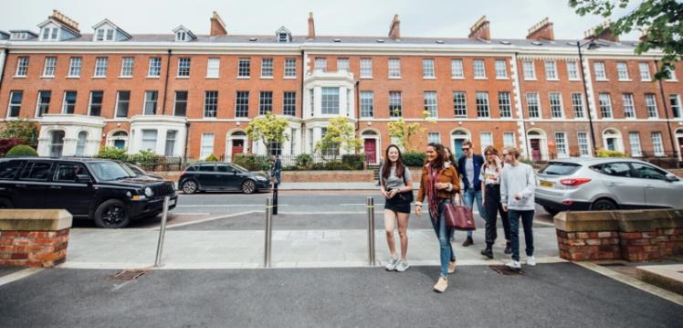 Group of students walking through QUB campus