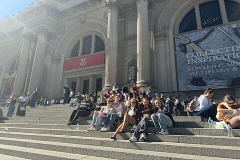 Students sitting on the steps of the MET