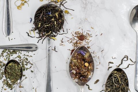 Various types of tea leaves on top of teaspoons