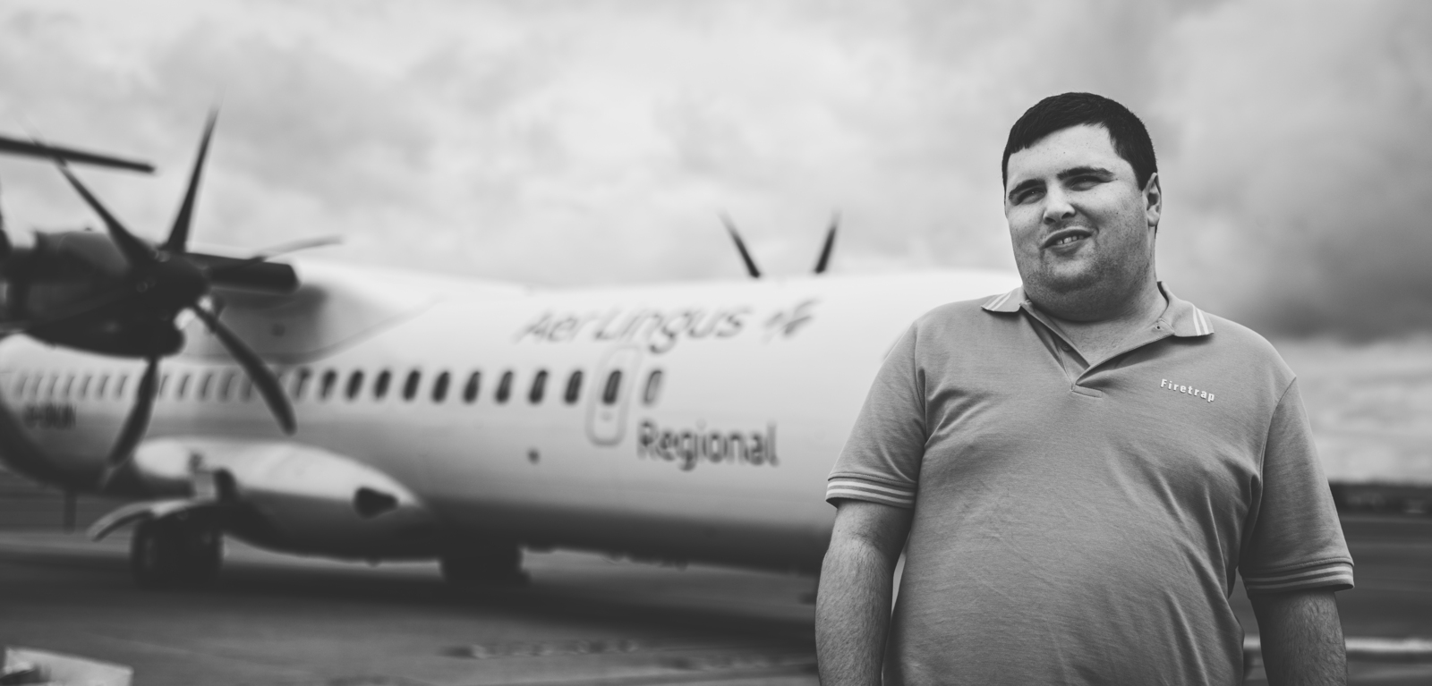 Black and white image of Thomas McClinton standing in front of Aer Lingus plane
