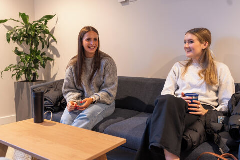 Two female students sitting in Queen's Business School